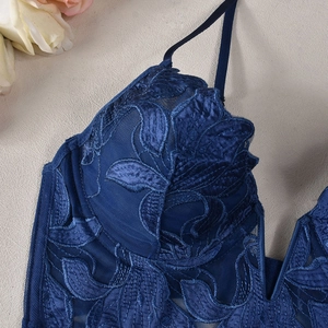 Detailed view of dark blue lace floral embroidery and mesh on deep V-neck bra