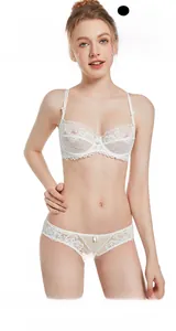 Détail d'un soutien-gorge en dentelle florale blanche fine avec culotte assortie et nœud