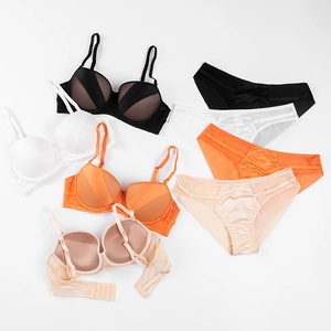 Flat lay of four-color push-up lingerie sets with satin finish and mesh panels