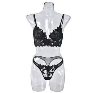 Detailed close-up of black lace floral embroidery on a sheer mesh lingerie set with thong