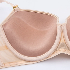 Close-up of seamless beige bra showing smooth cups and breathable mesh side wings