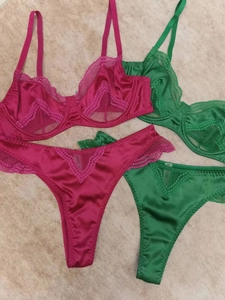 Detail of satin and floral lace patchwork bra sets in magenta and emerald green