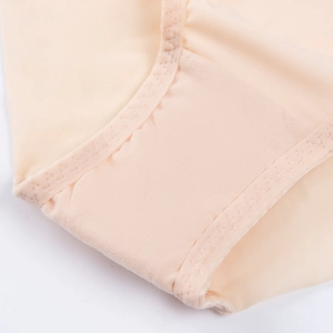 Close-up of zigzag stitching and mesh texture on beige push-up bra for women