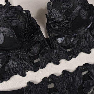 Close-up of black floral lace embroidery and mesh detailing on a deep V-neck bra