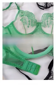 Detail view of green lace embroidery and double-row hook-and-eye closure on mesh bra