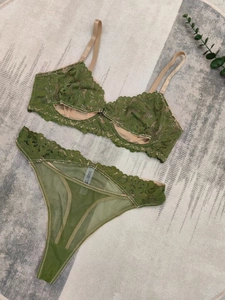 Platte weergave van olijfgroen kanten lingeriesetje met bloemenborduursel en label