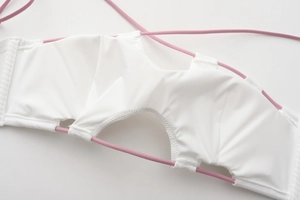 Detail of white stretch fabric with pink elastic cord lacing and precision stitching