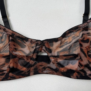 Detailed close-up of leopard print mesh bra with semi-transparent fabric and black straps