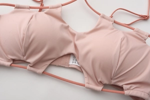 Detail of cross-back straps and care label on seamless wireless push-up bra
