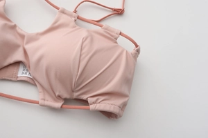 Close-up of pink bra detailing ruched fabric texture and delicate thin straps
