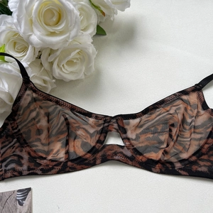 Macro detail of sheer mesh tiger print bra with underwire support and hollow design