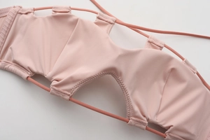 Detail of pink French-style bra featuring seamless fabric and hollow-out lace-up design