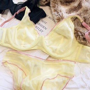 Detail of light yellow mesh lace lingerie set with pink straps and ruffled edges