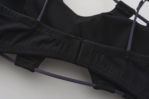 Close-up of the back multi-strap cross design and hook closure of the black lace bra