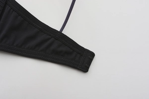 Macro detail of black wireless bra side wing with elastic fabric and metal hook closure