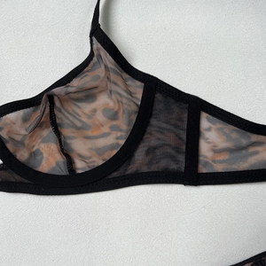 Close-up of leopard print mesh fabric and delicate black lace trim on the bra detail