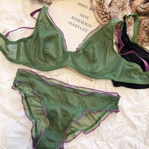 Detail of green sheer mesh lingerie set with purple wavy lace edges and underwire cups