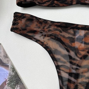 Detailed macro view of leopard print mesh lingerie set with intricate wavy black stitching
