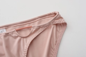 Detail of light pink seamless underwear showing fine fabric texture and cutout side design