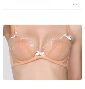 Detailed front view of a nude lace bra featuring low-center gore and delicate white bows