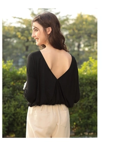 Detail of elegant black long-sleeve top with deep V-back design and breathable fabric