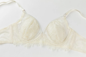 Détail de la dentelle florale ivoire et bordure de cils sur un soutien-gorge en tulle