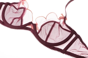 Close-up of wine red lace bra with delicate mesh fabric and satin bow detail