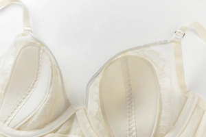 Gros plan sur le soutien-gorge en dentelle crème avec bonnets en tulle et boucles