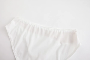Close-up of white seamless panties featuring fine zig-zag stitching and smooth mesh fabric