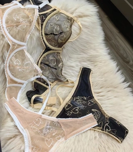 Détails d'ensembles de lingerie en dentelle avec broderie cœur sur fond en peluche douce