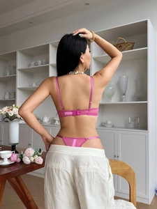 Detailed back view of pink lace bra with thin straps and satin finish embroidery
