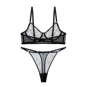 Détail d'un ensemble de lingerie en dentelle noire avec broderies de cœurs dorés