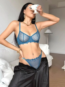 Detail of dark blue sheer lace bra and matching thong with elegant floral embroidery