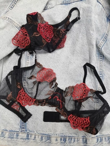 Detailed embroidery of red roses on semi-transparent black lace lingerie set