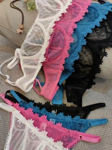 Flat lay of lace bras and panties with daisy embroidery in multiple colors