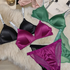 Flat lay of satin lingerie sets in multiple colors with mesh details on plush carpet