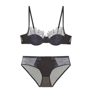 Detailed flat lay of black bra and panty set with delicate lavender eyelash lace trim