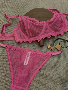 Detailed macro view of magenta floral lace bra and matching thong with intricate embroidery
