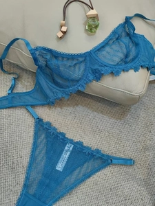 Detail of teal lace lingerie set with translucent mesh and washing label on the thong