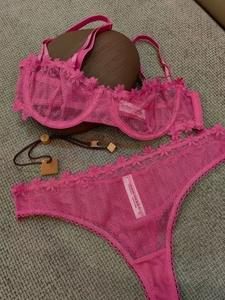 Détail de la broderie florale rose et de l'étiquette de lavage sur l'ensemble de lingerie