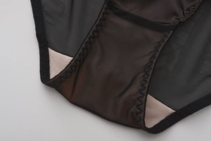 Macro shot of black mesh underwear showing cotton lining and reinforced stitching details