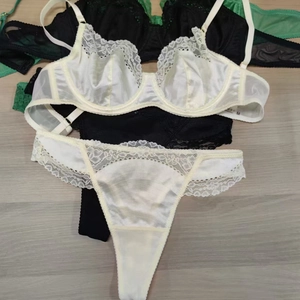Detailed stack of French ultra-thin lace lingerie sets in white, black and green colors