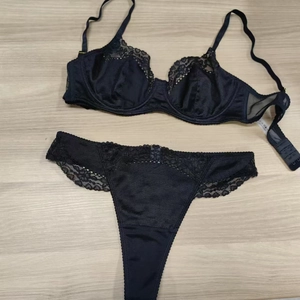 Detailed flat lay of black floral lace lingerie set with underwire bra and matching thong