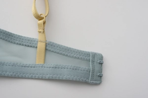 Detail of blue breathable mesh side wing and yellow adjustable strap of the bra