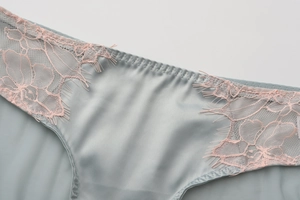 Close-up of French eyelash lace and light blue satin fabric on these women's panties