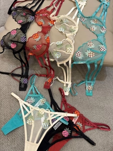 Detail view of sheer mesh lingerie sets featuring colorful pineapple embroidery motifs