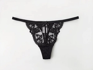 Detail view of black floral lace thong featuring delicate embroidery and a small bow tie