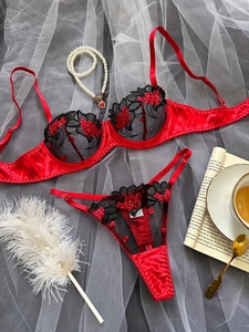 Flat lay of red floral embroidery lingerie set with black mesh and lace details