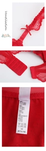 Détail d'un soutien-gorge en dentelle rouge avec nœuds, boucles et étiquette d'entretien