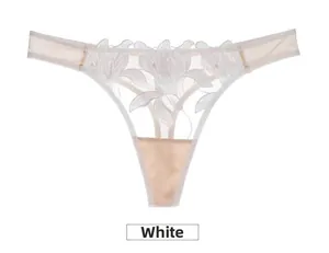 Détail de la broderie florale en dentelle blanche sur le string en résille transparent